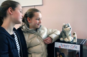 Twee jonge bezoeksters genoten zaterdag van hun reparatie-moment: het beeldje werd gelijmd en het knuffelbeest geheeld door vrijwilligers van Repair Café Oegstgeest.  Foto Frans Malten